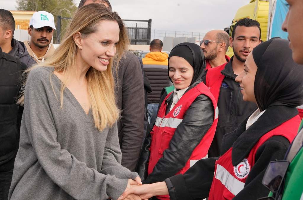 La actriz y productora cinematográfica estadounidense Angelina Jolie, al frente, izquierda, saluda a trabajadores de la Media Luna Roja durante su visita al cruce fronterizo de Rafah, entre Egipto y la Franja de Gaza, en Rafah, Egipto, el viernes 2 de enero de 2026