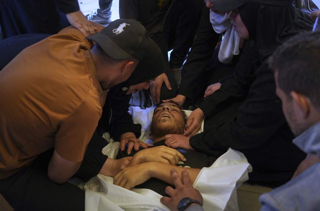Palestinos lloran el cuerpo de Ahmed Abu Hilal, quien murió mientras se dirigía a un centro de ayuda humanitaria en Gaza, durante su funeral en el Hospital Nasser de Khan Younis, en el sur de la Franja de Gaza, el domingo 8 de junio de 2025