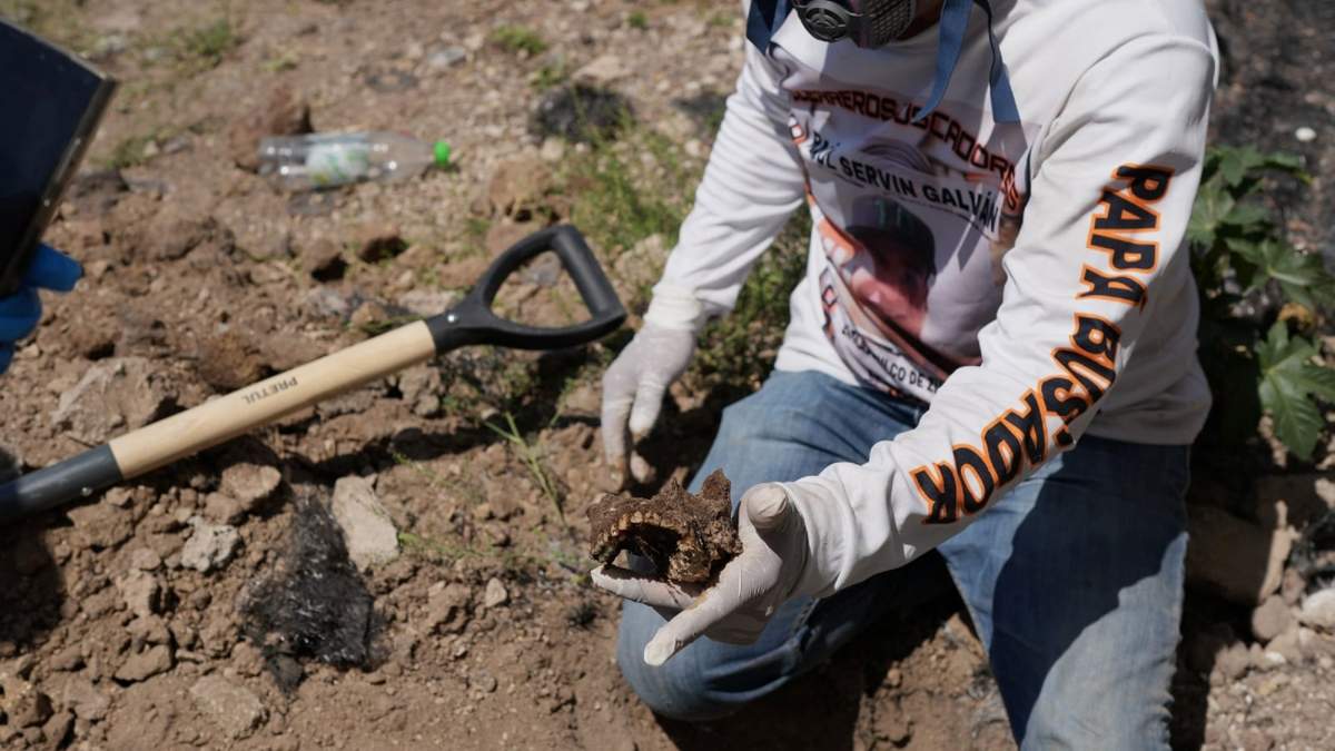 Raúl Servín, miembro del grupo Guerreros Buscadores y cuyo hijo desapareció hace ocho años, sostiene restos óseos encontrados en Tlajomulco de Zúñiga