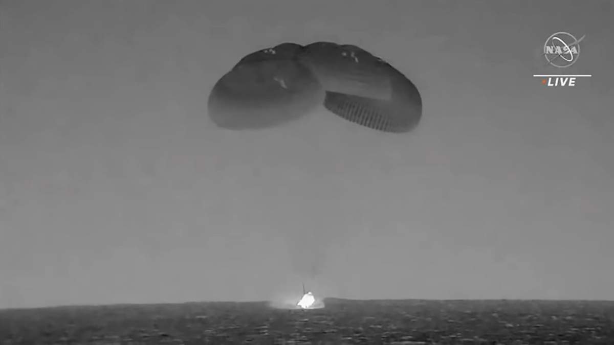 Una cápsula de SpaceX --con paracaídas desplegados para disminuir su velocidad-- cae en el Océano Atlántico