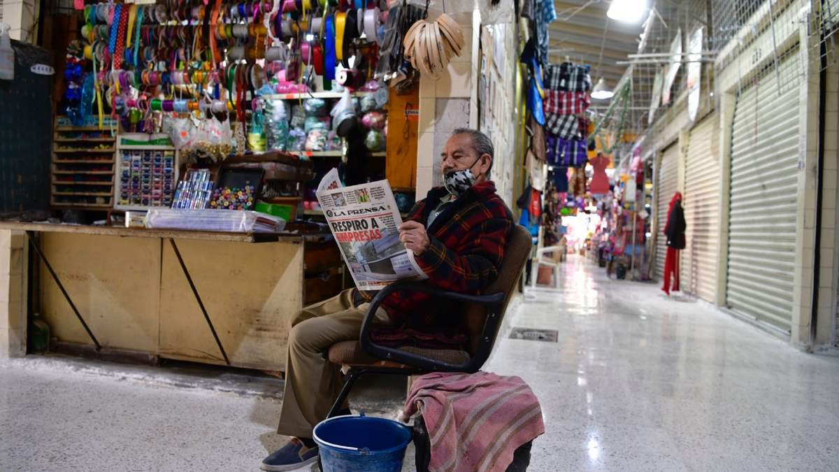 Un comerciante lee el periódico en pandemia