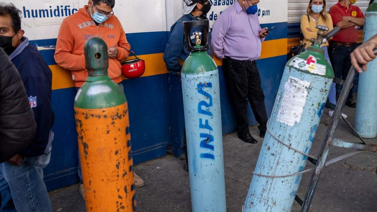 Personas hacen fila para rellenar sus tanques de oxígeno en una sucursal de Infra