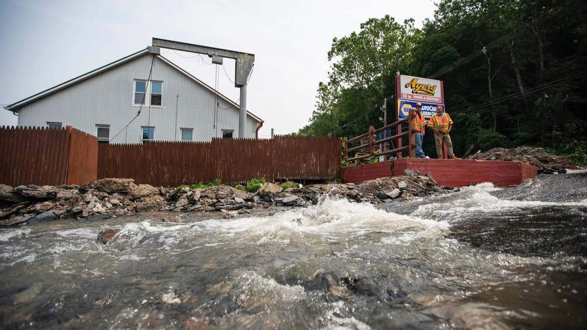 Una corriente de agua se desplaza en un camino afectado por las recientes tormentas, el lunes 17 de julio de 2023, en Belvidere, Nueva Jersey