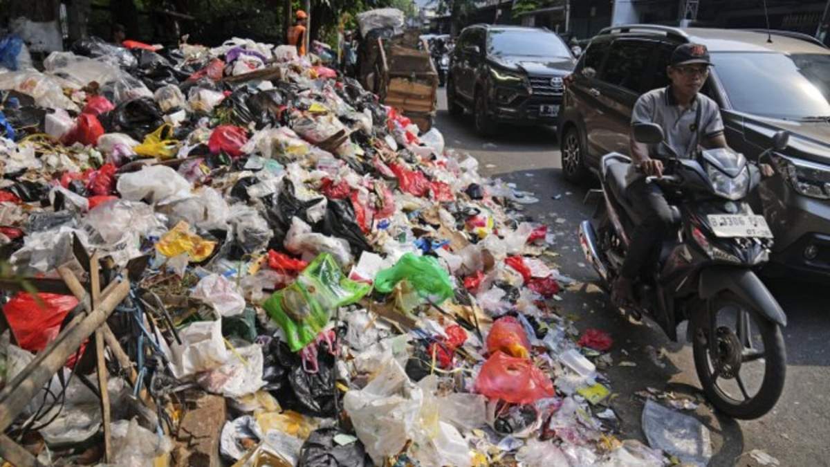 Conductores pasan al lado de un cerro de basura, en su mayoría plástico, en una calle en Yakarta, Indonesia, el martes 26 de noviembre de 2024