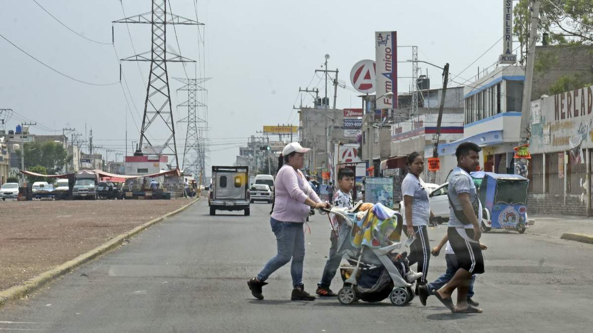 Una familia cruza una avenida en el municipio de Chimalhuacán, en plena pandemia