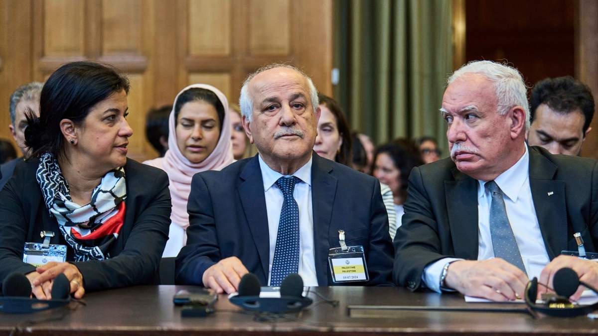 El asesor palestino de política exterior, Riad Malki, y otros miembros del equipo jurídico palestino toman asiento antes de que los jueces ingresen a la Corte Internacional de Justicia