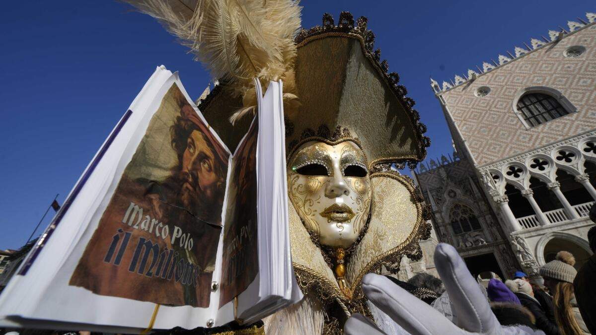 Un hombre, ataviado con una máscara, sostiene una réplica de “Los viajes de Marco Polo”, que relatan los viajes del explorador por Asia, durante el Carnaval en Venecia, Italia, el 28 de enero de 2024. Venecia conmemora el 700 aniversario de la muerte de Marco Polo con un año de actos que comenzaron con un inicio del Carnaval dedicado a uno de los hijos más ilustres de la ciudad de los canales. ()