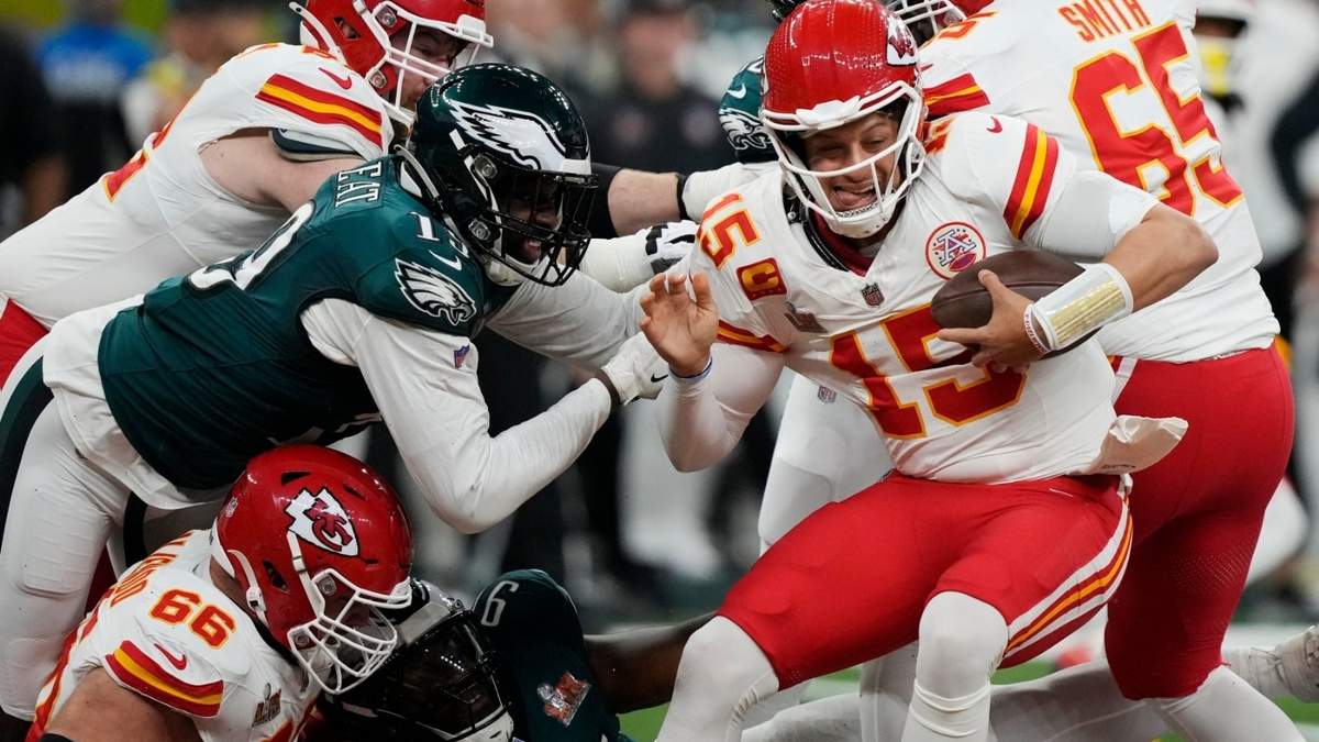 El quarterback de los Chiefs de Kansas City, Patrick Mahomes (15), intenta evitar el alcance del apoyador de los Eagles de Filadelfia, Josh Sweat, a la izquierda, durante la primera mitad del partido de fútbol americano del Super Bowl 59 de la NFL, el domingo 9 de febrero de 2025, en Nueva Orleans