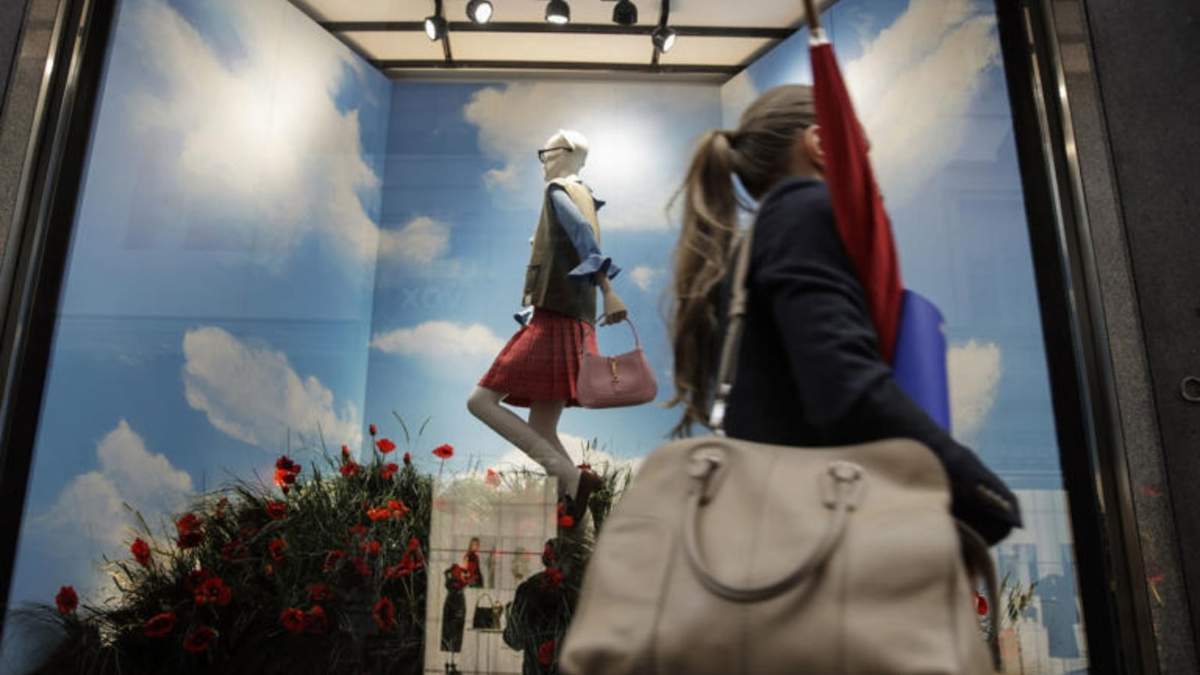 Una mujer camina frente al escaparate de una tienda de Gucci en el distrito de moda de Vía Montenapoleone, en Milán, Italia