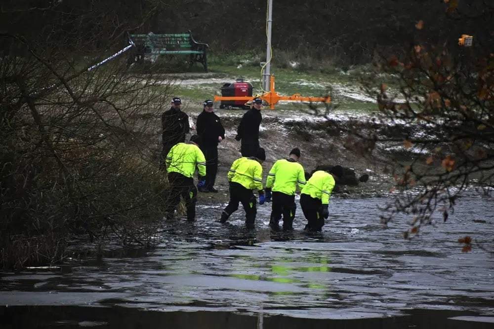 Equipos de búsqueda de la policía buscan en un lago congelado luego de que cuatro niños cayeron a las aguas gélidas en Babbs Mill Park en Kingshurst, Solihull, Inglaterra, el 12 de diciembre de 2022
