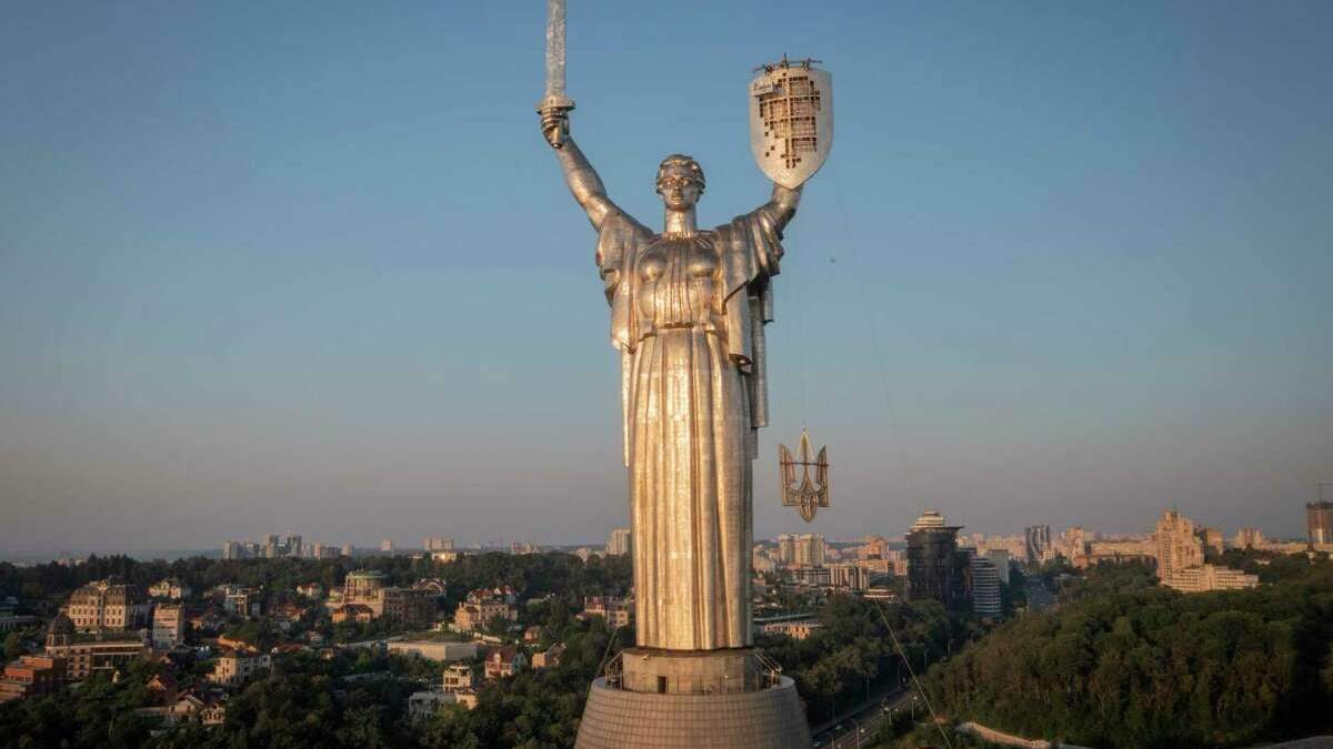 Trabajadores instalan el escudo de armas de Ucrania en el escudo de la estatua más alta del país, el Monumento a la Madre Patria, después de que se retirase el escudo de armas soviético, en Kiev, Ucrania, el domingo 6 de agosto de 2023. Ucrania está acelerando los esfuerzos de borrar los vestigios de la influencia soviética y rusa del espacio público en medio de la invasión rusa de Ucrania