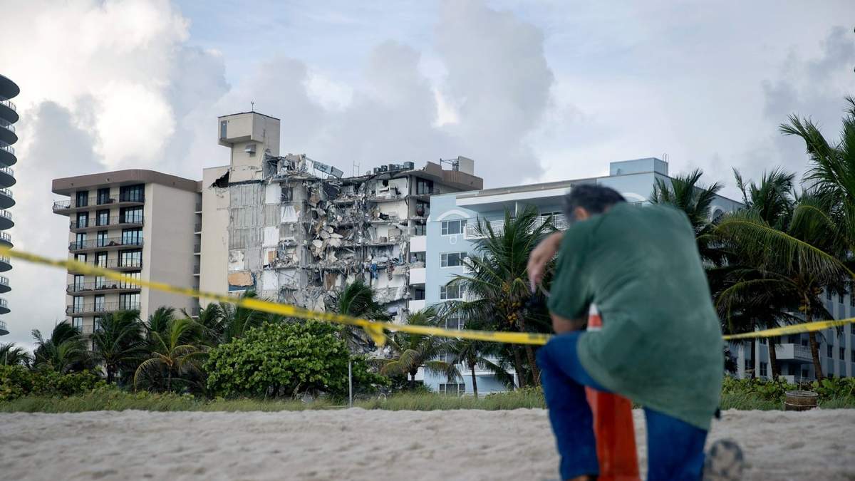 Un hombre se arrodilla frente al edificio colapsado de Miami Dade, en el estado de Florida. Fuente: (Twitter)