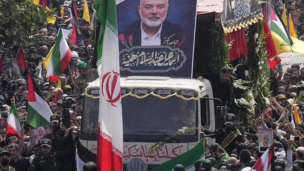 Iraníes siguen el jueves 1 de agosto de 2024 un camión que lleva los ataúdes del dirigente político de Hamás, Ismail Haniyeh, y su guardaespaldas, que fueron asesinados en un ataque que ha sido atribuido a Israel y que fue perpetrado en la víspera, durante su funeral en Teherán, Irán