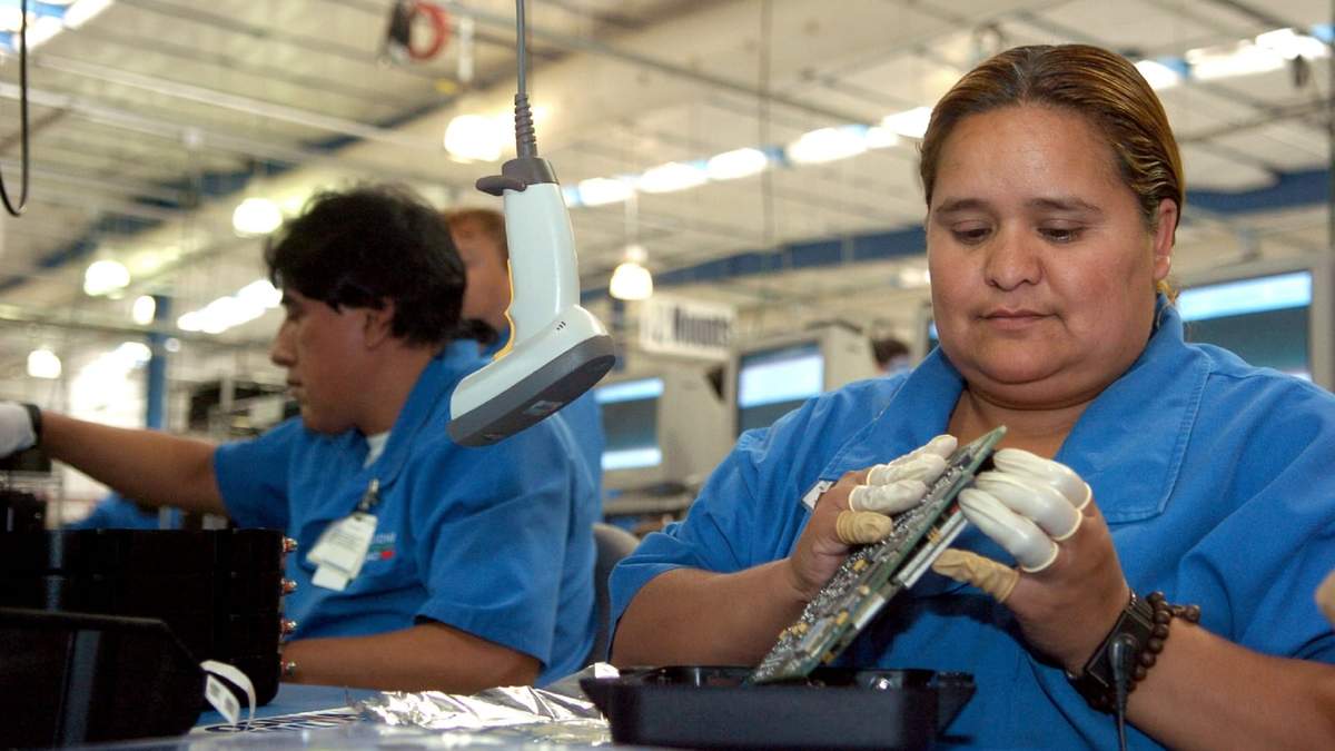 Hombre y mujer trabajan en una maquila de cómputo en Tijuana, Baja California Norte