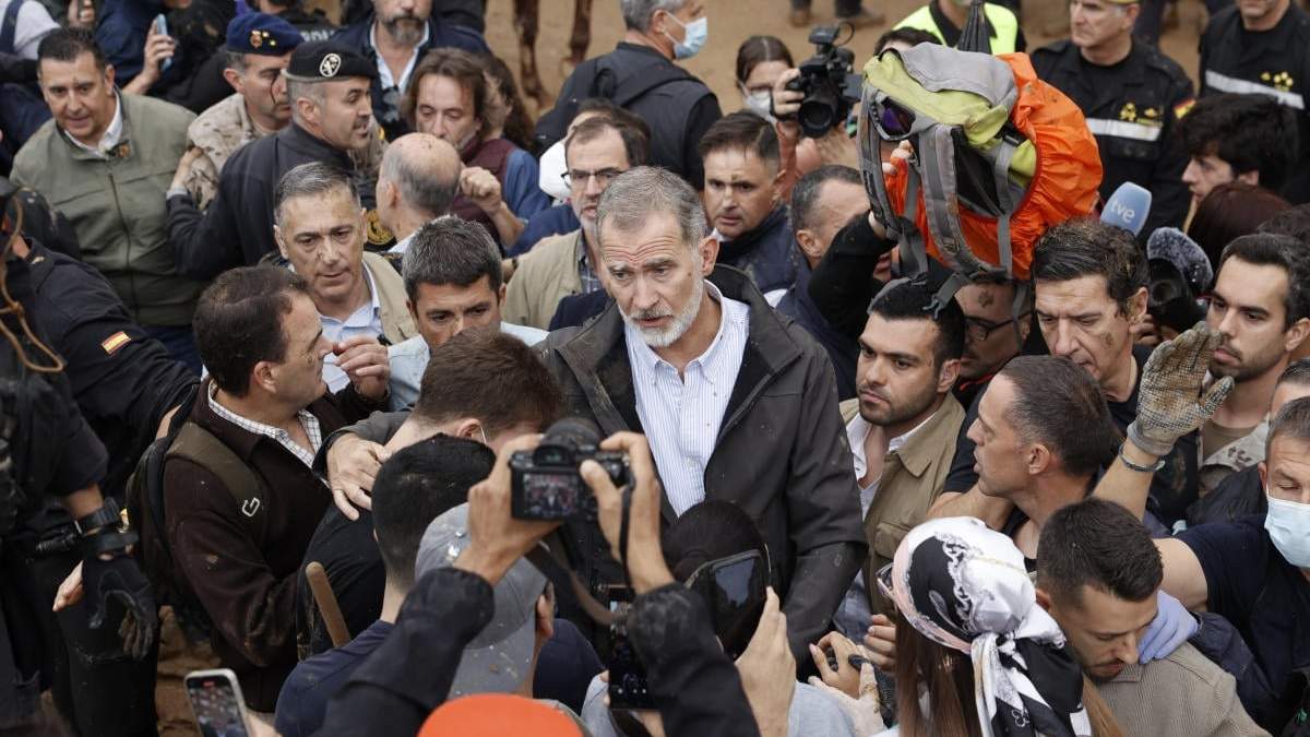 El rey Felipe VI de España, en el centro, habla con habitantes en Paiporta, cerca de Valencia, España. Una multitud de sobrevivientes enfurecidos por las inundaciones en España arrojaron lodo y gritaron insultos al rey y a funcionarios cuando realizaron su primera visita a una de las ciudades más afectadas