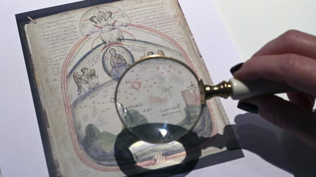 Christina Sotirakoglou, una experta en caligrafía, observa pinturas bizantinas en fotografías impresas, en su oficina en Salónica, en el norte de Grecia