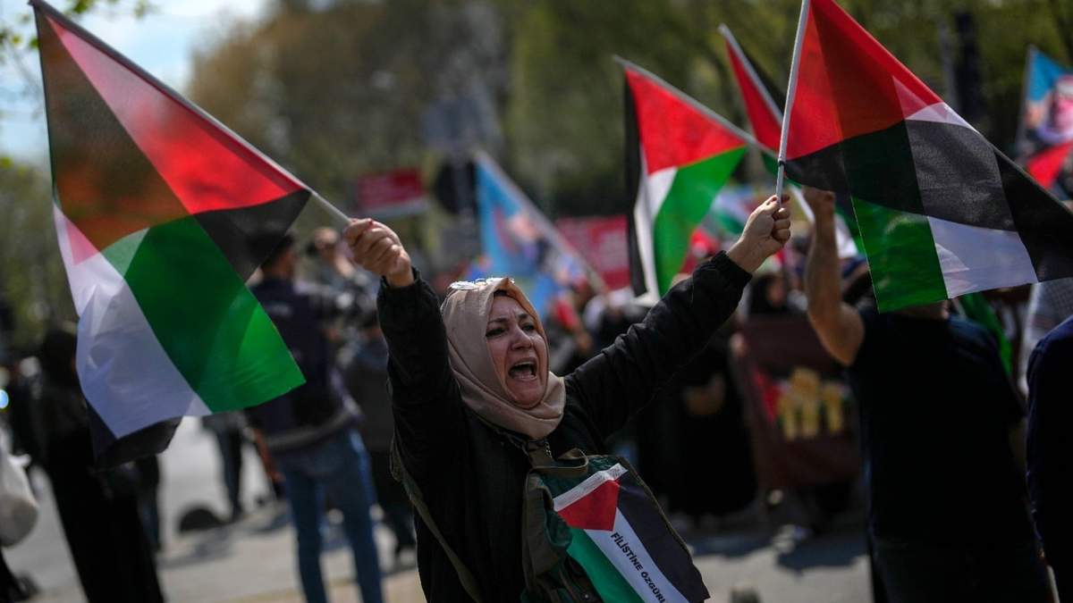 Una mujer ondea banderas en apoyo a los palestinos en la Franja de Gaza durante una protesta, el viernes 5 de abril de 2024, en Estambul.