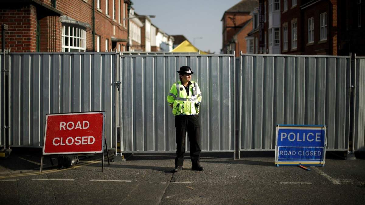 Un policía custodia una valla metálica erigida al final de la calle Rollestone, donde se encuentra la Casa John Baker para personas sin hogar, en Salisbury, Inglaterra, el jueves 5 de julio de 2018