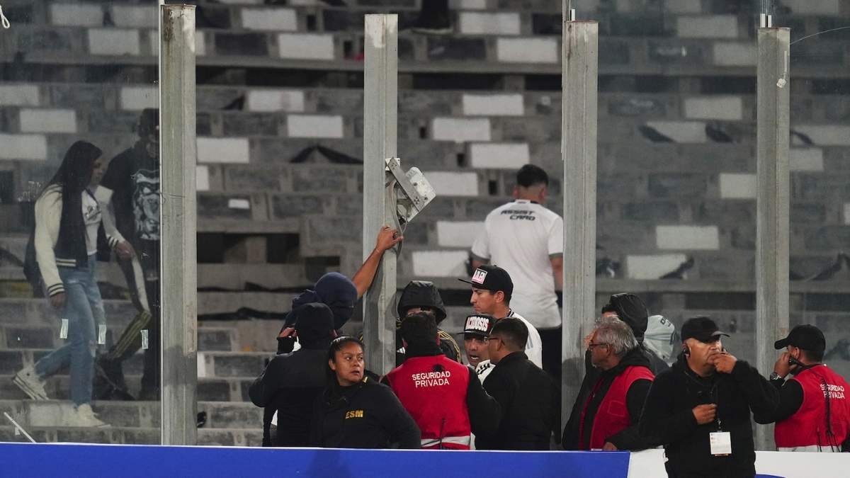 Empleados de seguridad confrontan a algunos aficionados, tras la ruptura de paneles transparentes y la invasión de la cancha durante el partido de la Copa Libertadores entre Colo Colo de Chile y Fortaleza de Brasil