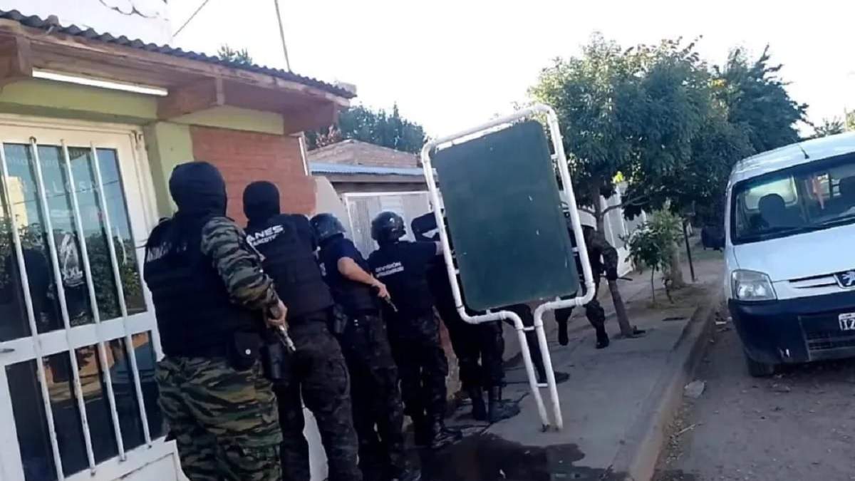 Uniformados de la división Antinarcóticos a unto de irrumpir en una de las viviendas allanadas en Senillosa. Fuente: (Neuquén Informa)