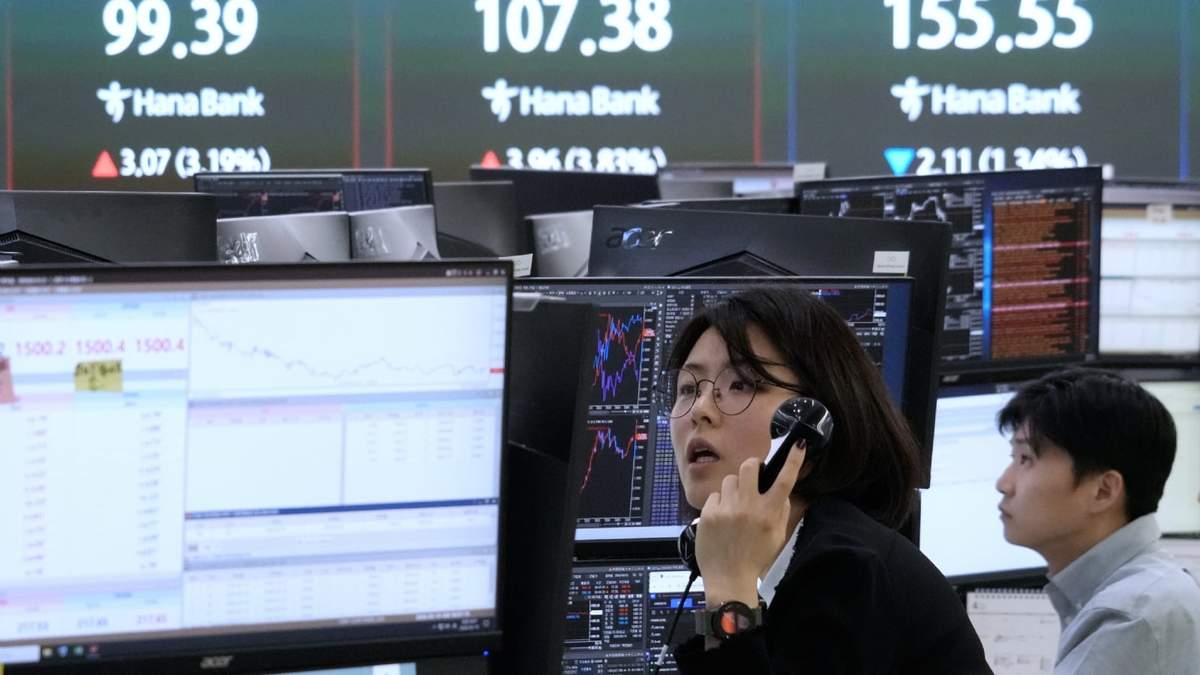 Una corredora de divisas trabaja junto a una pantalla en la que se muestran los precios internacionales del petróleo en la sala de operaciones de la sede central del Hana Bank en Seúl, Corea del Sur, el jueves 19 de marzo de 2026