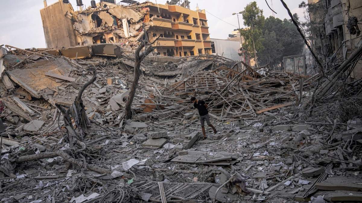 Un palestino busca en  los escombros de un edificio después de que fue alcanzado por un ataque aéreo israelí, en la ciudad de Gaza