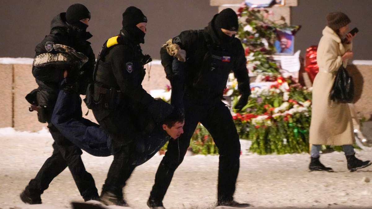 Agentes de policía detienen a un hombre que deposita flores a Alexei Navalny en el Memorial a las Víctimas de la Represión Política en San Petersburgo, Rusia