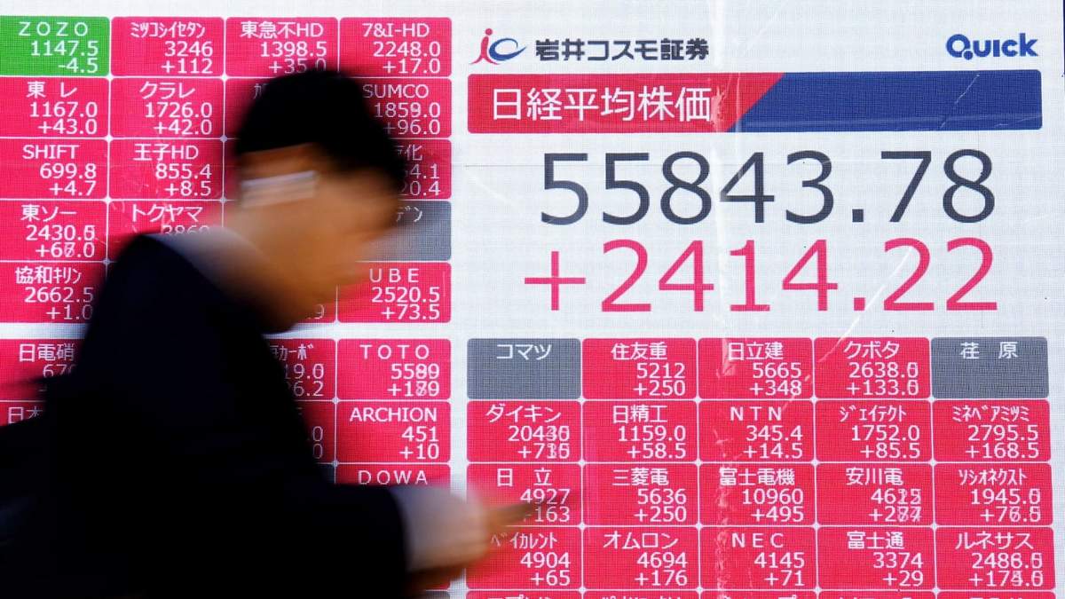 Una persona pasa ante una pantalla con el índice bursátil japonés Nikkei, en Tokio, el miércoles