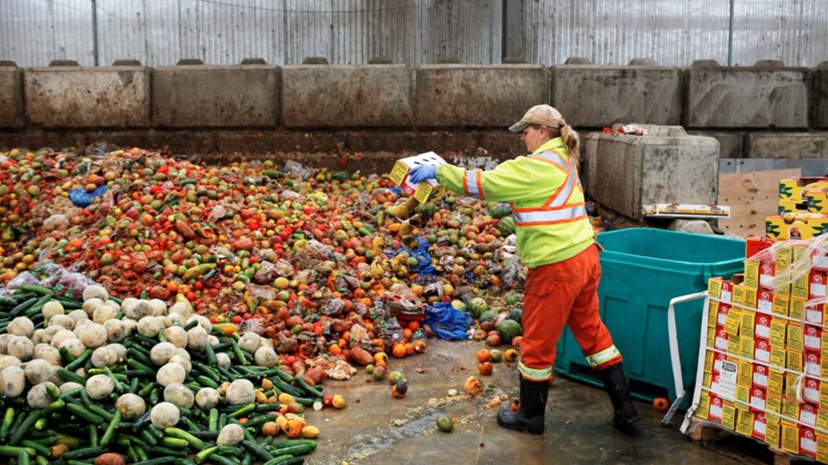 Trabajadora desechando kilos de fruta y verdura de un supermercado en España