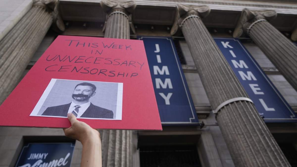Un manifestante sostiene un cartel frente al Centro de Entretenimiento El Capitán, donde se presenta el programa nocturno "Jimmy Kimmel Live!"