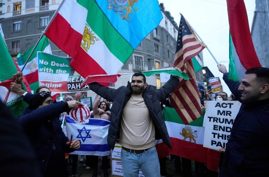Un manifestante iraní rompe la bandera del Estado Islámico durante una manifestación frente al Consulado de Estados Unidos en Milán, Italia, el martes 13 de enero de 2026, en apoyo a las protestas masivas a nivel nacional en Irán contra el gobierno