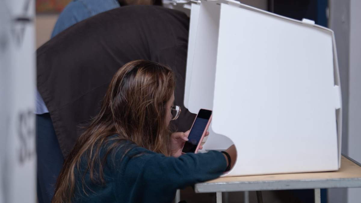 Mujer utiliza su teléfono al momento de emitir su voto durante la jornada electoral de este 1 de junio de 2025