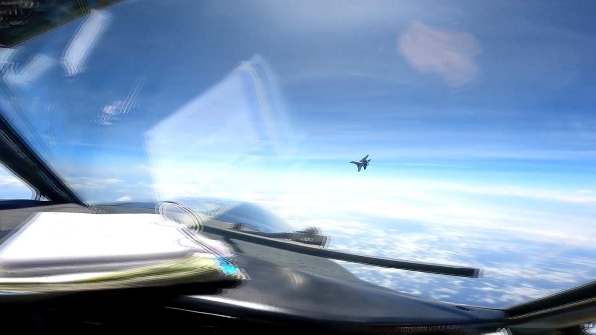 En esta imagen tomada de un video difundido por la Marina de Estados Unidos, un avión de combate J-16 vuela agresivamente cerca de una aeronave estadounidense RC-135