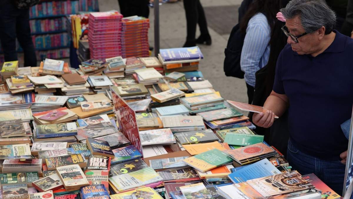 Un hombre observa algunos libros en venta durante la FILGAM