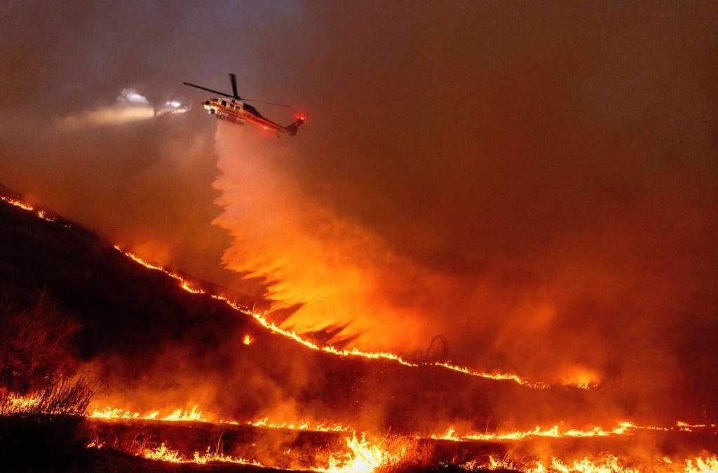 Un helicóptero arroja agua sobre el incendio Kenneth en West Hills, Los Ángeles