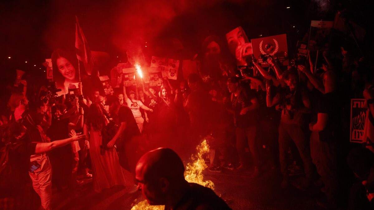 Manifestantes encienden un fuego durante una protesta contra el gobierno del primer ministro israelí, Benjamin Netanyahu, y piden la liberación de los rehenes retenidos en la Franja de Gaza por Hamás y otros grupos armados, en Tal Aviv