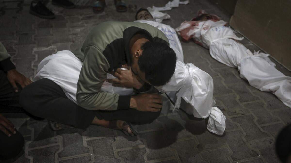 Un joven palestino llora a un familiar fallecido en el bombardeo israelí sobre la Franja de Gaza en la morgue del Hospital Kuwaití en el campo de refugiados de Rafah, en el sur de la Franja de Gaza