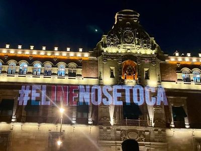 Unidos ilumina Palacio Nacional con la leyenda #ElINENoSeToca