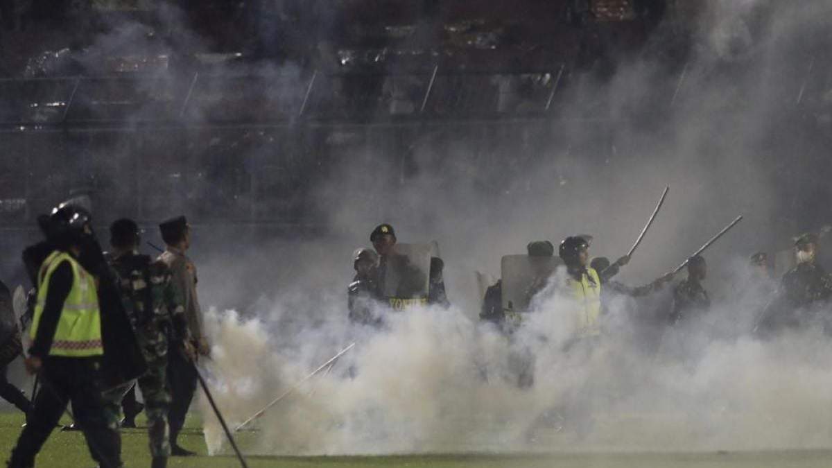 La policía lanza gases lacrimógenos a aficionados que entraron al campo en un partido de futbol entre dos rivales en Malang, Indonesia