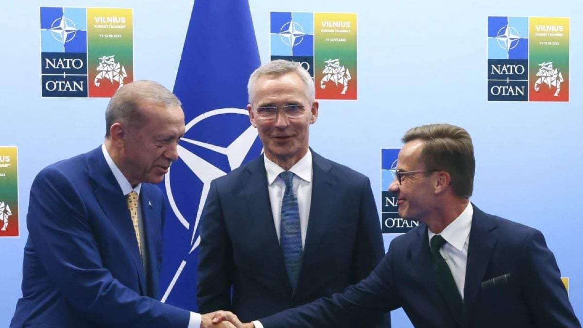 El presidente turco Recep Tayyip Erdogan (I) le da la mano al primer ministro de Suecia, Ulf Kristersson, (D), mientras el secretario general de la OTAN, Jens Stoltenberg, observa, en Vilna, Lituania