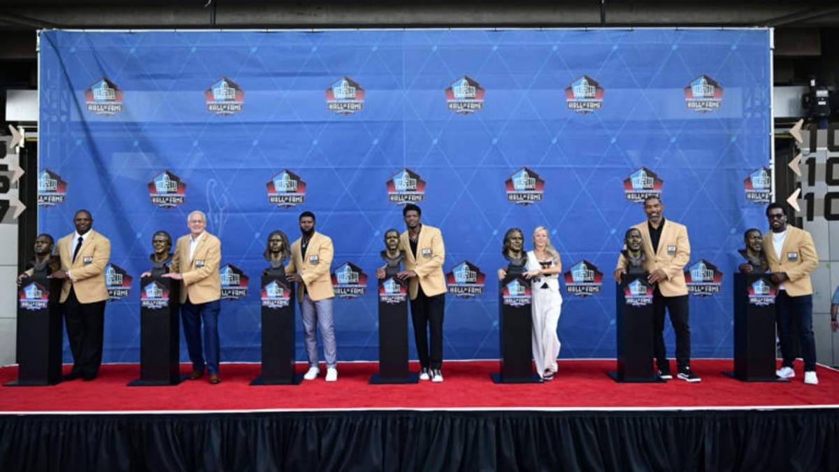 La clase 2024 del Salón de la Fama posa con sus busos durante la ceremonia de inducción en Canton, Ohio