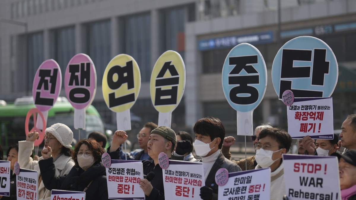 Manifestantes exigen que se detengan las maniobras militares entre EU y Corea del Sur. Los carteles dicen "Alto al ejercicio de guerra"