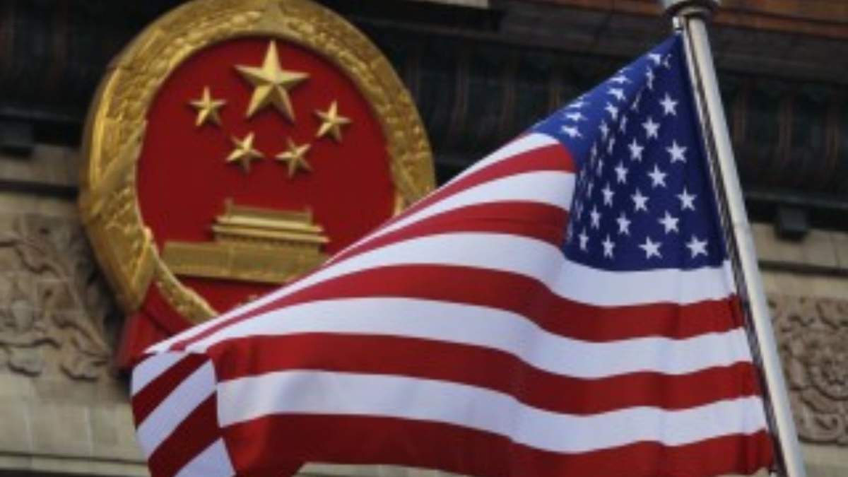 Una bandera estadounidense ondea cerca del emblema nacional de China, fuera del Gran Salón del Pueblo, en Beijing, el 9 de noviembre de 2017