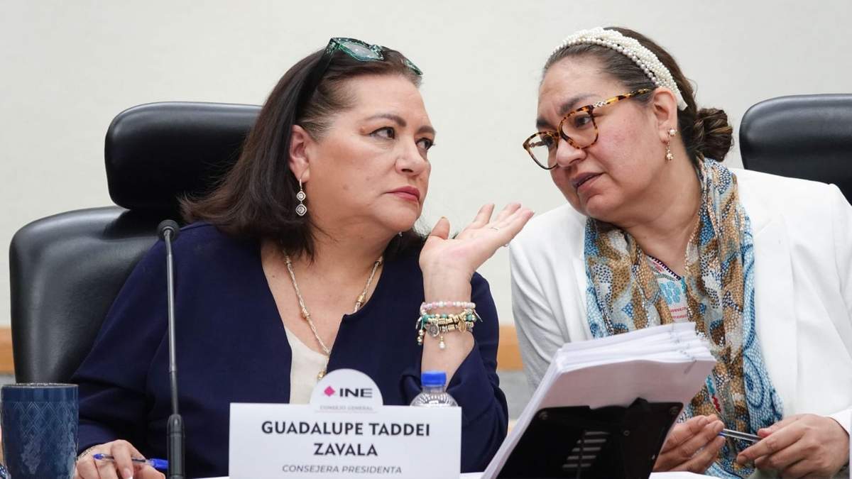 Guadalupe Taddei y la secretaria ejecutiva Claudia Arlett Espino conversan durante la sesión extraordinaria del Consejo General del INE