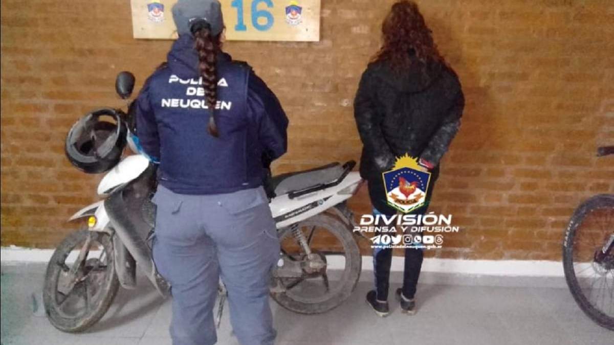 La mujer demorada junto a una de las motocicletas recuperadas. Fuente: (Policía de Neuquén)
