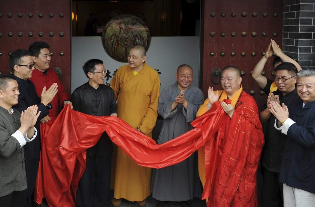 Foto del 28 de junio del 2015 que muestra a Shi Yongxin, tercero de la derecha en bata amarilla y roja, abad del Templo Shaolin, en la inauguración de un centro en Xi'an en la provincia de Shaanxi en China