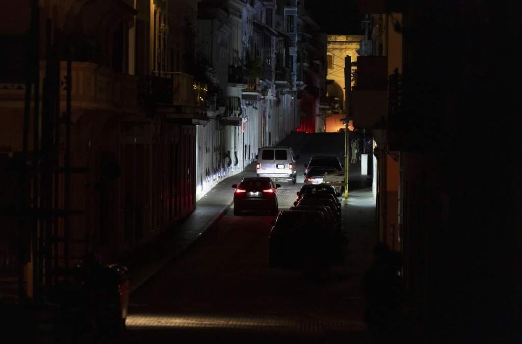 Automóviles transitan por una calle oscura en el Viejo San Juan, Puerto Rico, en medio de un apagón de extensión nacional, miércoles 16 de abril de 2025