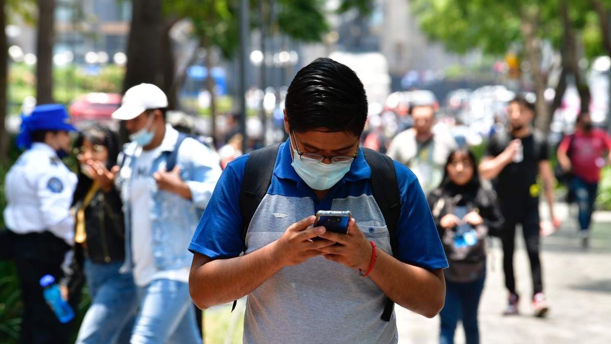 Un joven usando su celular