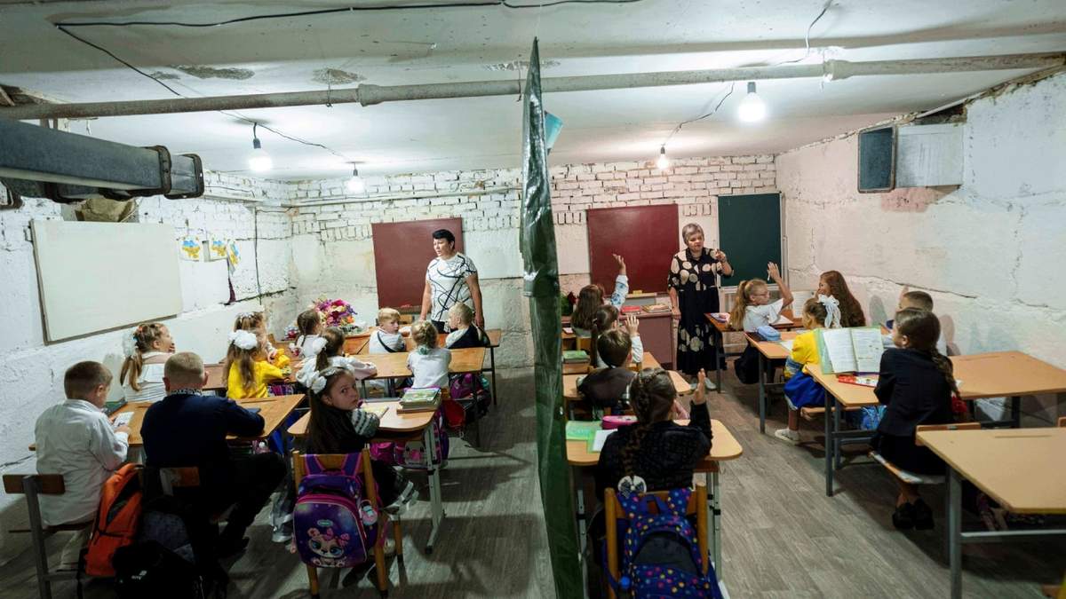 Alumnos escuchan a sus profesores durante una clase en el sótano de un edificio municipal durante el primer día de clases, en Bobryk, región de Sumy, Ucrania