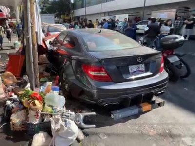 Joven choca su Mercedes Benz contra puestos de comida